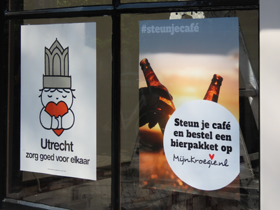 848999 Afbeelding van twee affiches die betrekking hebben op de coronacrisis, op een raam van café De Morgenster ( ...